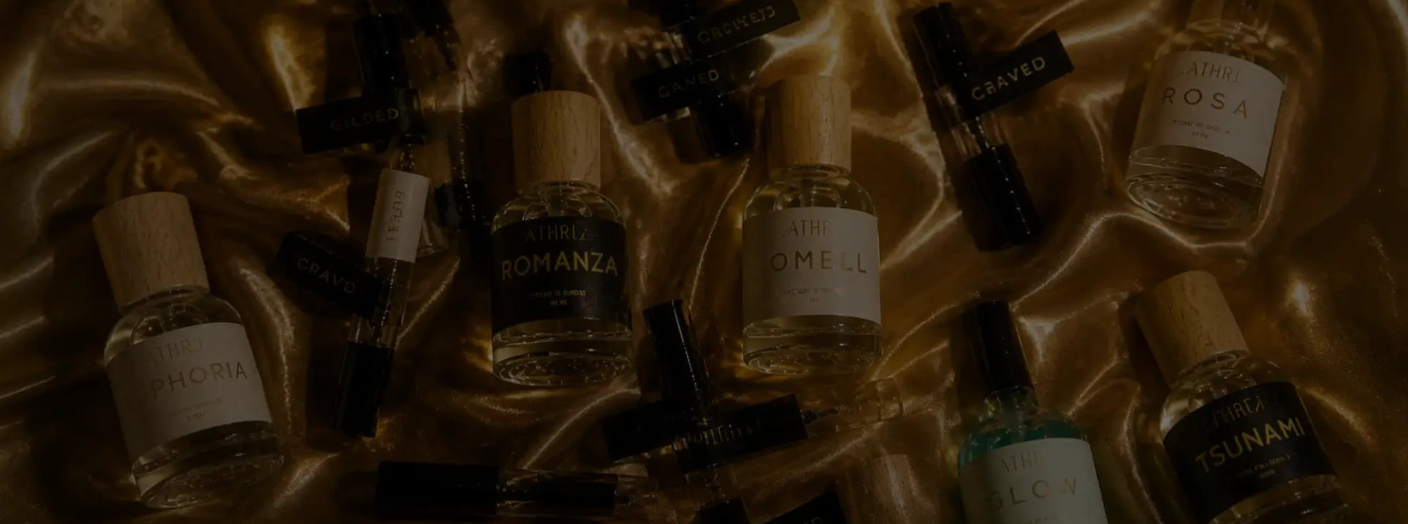 Collection of small bottles with labels on a gold satin background