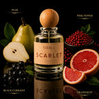 A perfume bottle labeled 'A1M3 SCARLET' centered on a black reflective surface, surrounded by fruit and berries representing the scent notes: pear, pink pepper, black currant, and grapefruit. The bottle has a round wooden cap and a beige label.
