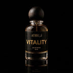 A 50 ml bottle of Athri Vitality Eau de Parfum with a dark wood-grain spherical cap, set against a solid black background with a subtle reflection below.