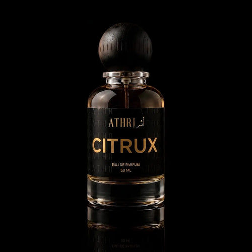 A 50 ml bottle of Athri Citrux Eau de Parfum with a black label and a dark wooden spherical cap, set against a solid black background with a subtle reflection below.