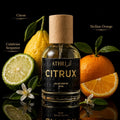 Athr Citrux perfume bottle with citrus fruits on a reflective surface