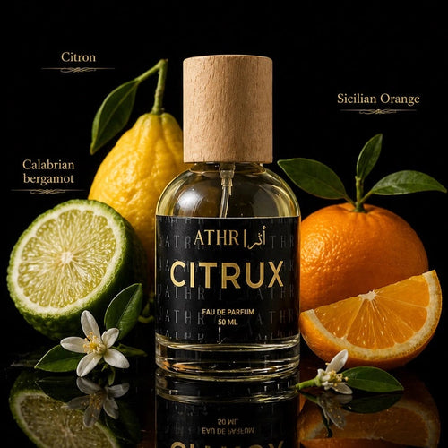 Athr Citrux perfume bottle with citrus fruits on a reflective surface
