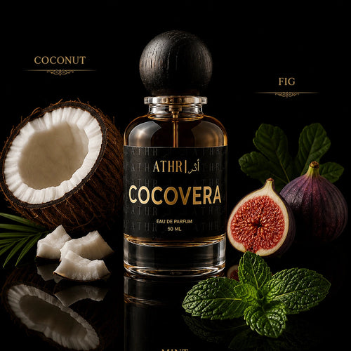A bottle of ATHRiCOCOVERA coconut and fig eau de parfum, 50 ml, displayed on a reflective black surface with fresh coconut, figs, mint leaves, and mint buds around it.