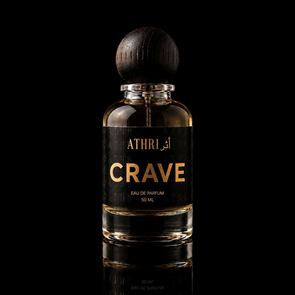 A 50 ml bottle of Athri Crave Eau de Parfum with a black label and a dark wooden spherical cap, set against a solid black background with a subtle reflection below.