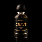 A 50 ml bottle of Athri Crave Eau de Parfum with a black label and a dark wooden spherical cap, set against a solid black background with a subtle reflection below.