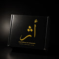 A black rectangular product box with gold Arabic calligraphy and the text 'Smell Different, Be Unforgettable' and 'www.athregy.