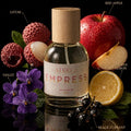 Bottle of Athr Empress perfume with fruits and flowers on a black background