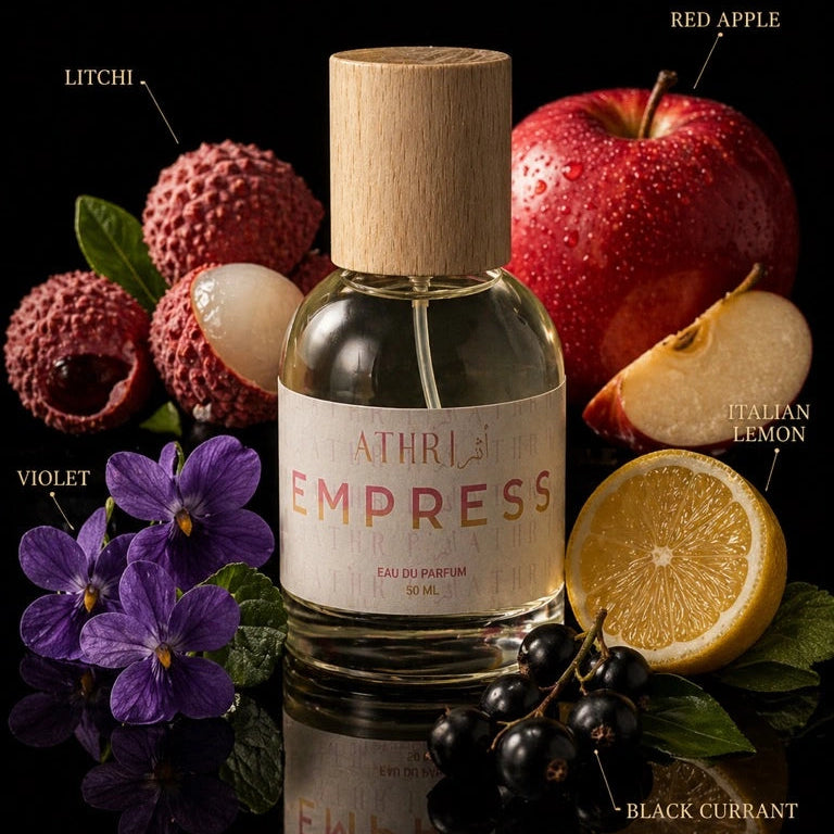 Bottle of Athr Empress perfume with fruits and flowers on a black background