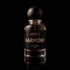 A 50 ml bottle of Athri Harmony Eau de Parfum with a black label and a dark wooden cap, set against a solid black background with a subtle reflection below.