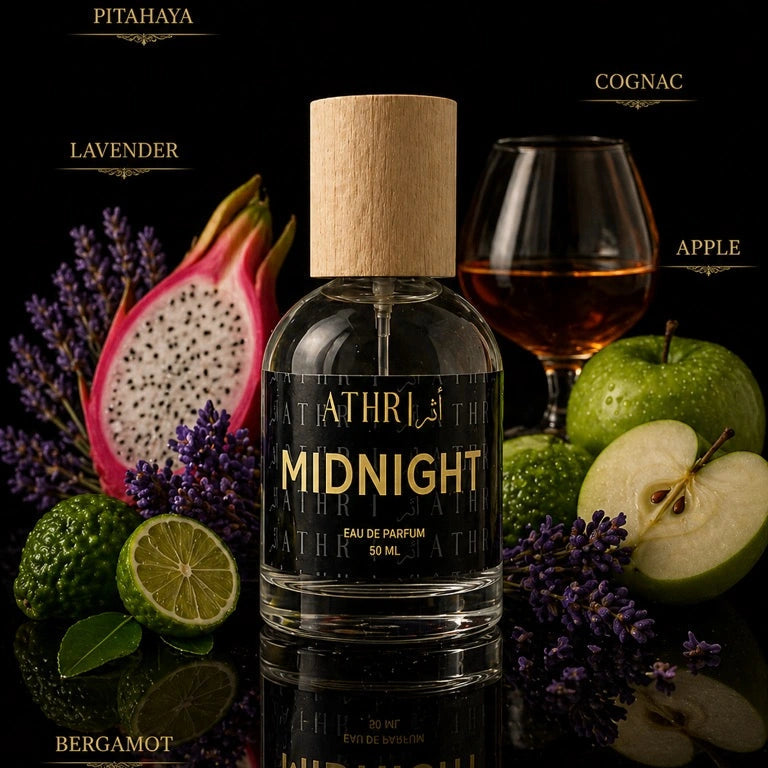 Athr Midnight eau de parfum bottle with fruits, flowers, and a glass of cognac on a dark background.