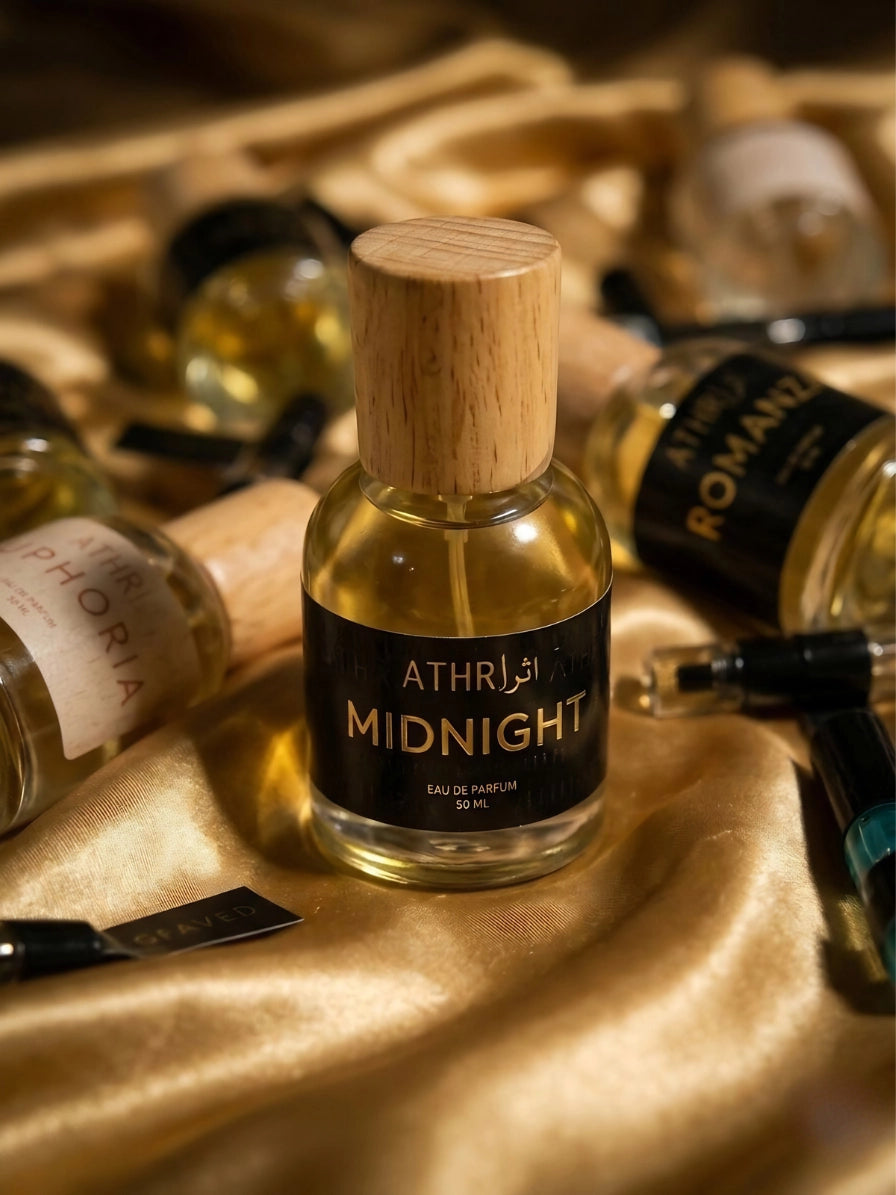 Bottle of Athr Midnight perfume with wooden cap on a gold fabric background