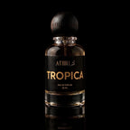 A 50 ml bottle of Athri Tropica Eau de Parfum with a black label and a dark wooden cap, set against a solid black background with a subtle reflection below.
