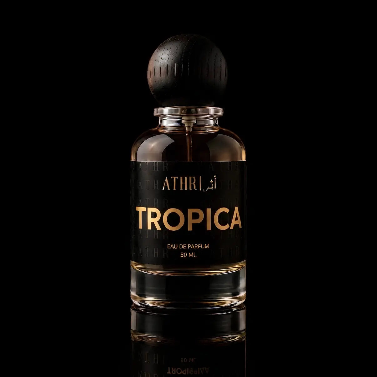 A 50 ml bottle of Athri Tropica Eau de Parfum with a black label and a dark wooden cap, set against a solid black background with a subtle reflection below.