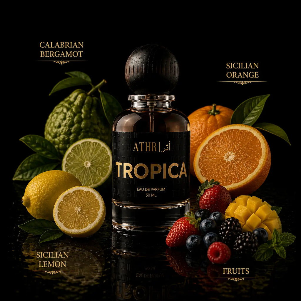 A bottle of ATHRI TROPA Eau de Parfum centered on a black reflective surface, surrounded by citrus fruits, berries, and green leaves. Text labels identify Calabrian Bergamot, Sicilian Orange, Sicilian Lemon, and Fruits.