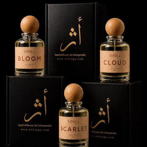 Three perfume bottles with round wooden caps and beige labels are arranged with their black boxes on a black background. The front bottle is labeled SCARLET, the left bottle is labeled BLOOM, and the right bottle is labeled CLOUD.